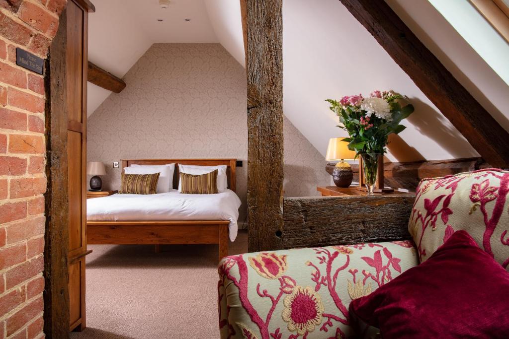 a attic room with two beds and a couch at Broom Hall Inn in Stratford-upon-Avon