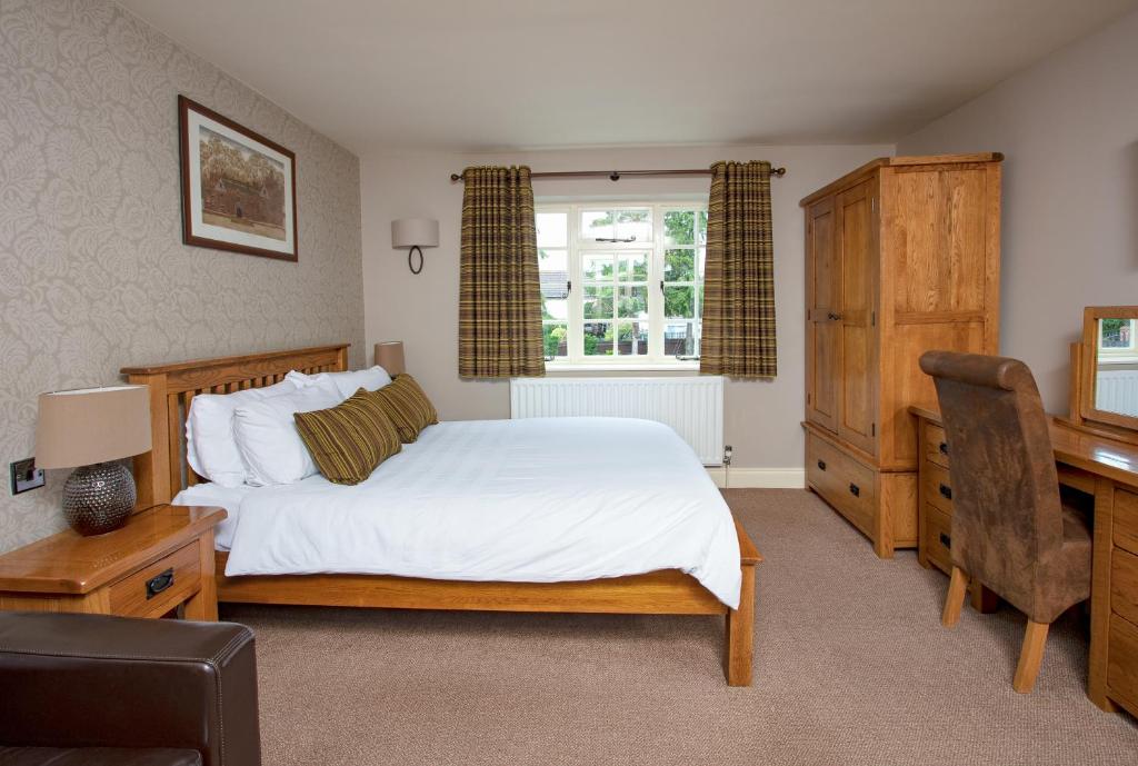 a bedroom with a bed and a desk and a chair at Broom Hall Inn in Stratford-upon-Avon