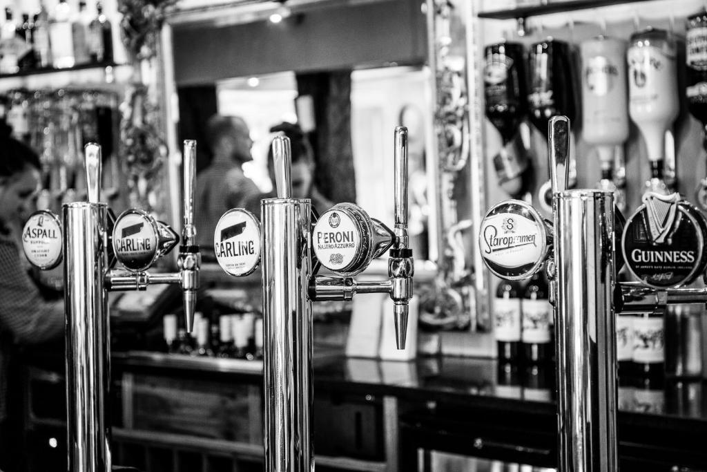 a bar with a bunch of beer taps in a bar at Broom Hall Inn in Stratford-upon-Avon