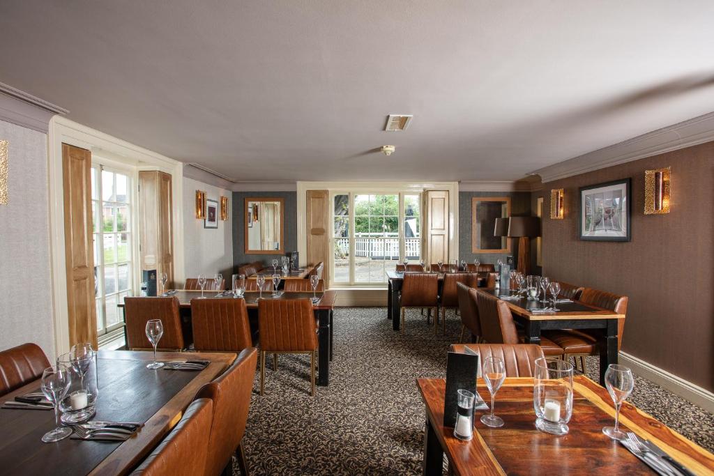 a restaurant with tables and chairs and a dining room at Broom Hall Inn in Stratford-upon-Avon