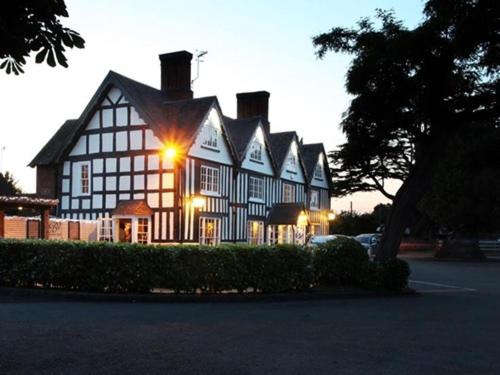 a large black and white building with a lot of windows at Broom Hall Inn in Stratford-upon-Avon