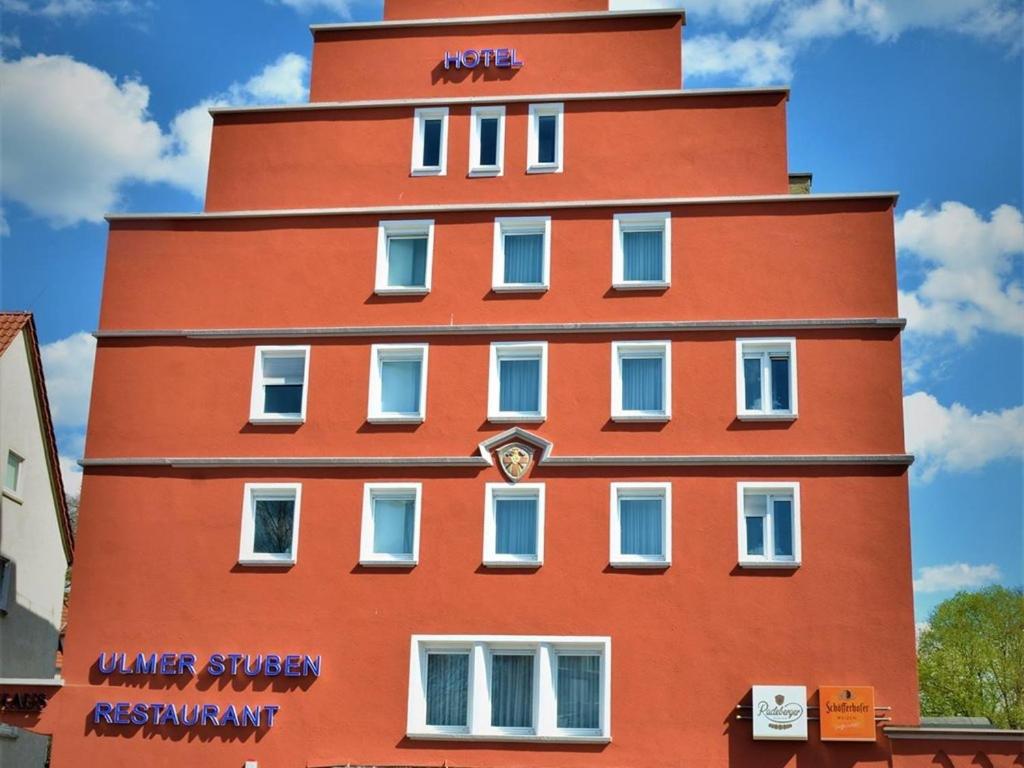 a tall red building with a clock on it at Hotel Ulmer Stuben in Ulm