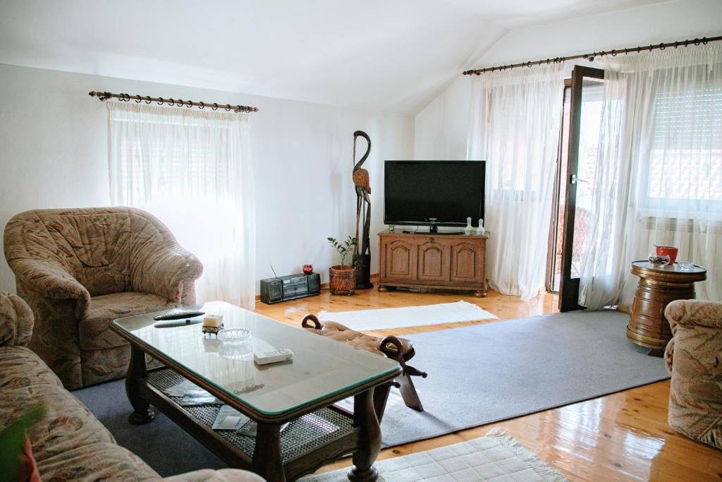 - un salon avec un canapé, une table et une télévision dans l'établissement Apartment Ikar, à Mostar