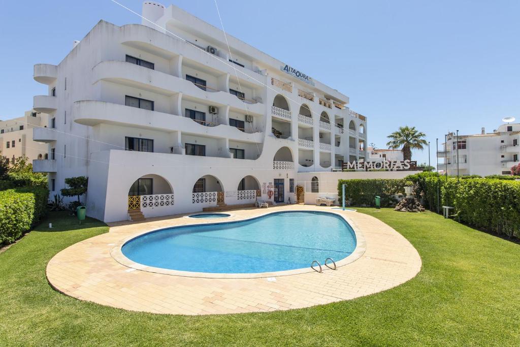 einem Pool vor einem großen Gebäude in der Unterkunft Apartamento Caju by Algarve Holidays in Albufeira