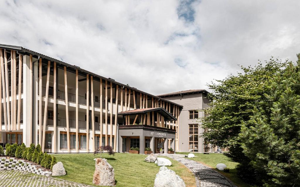 un edificio de oficinas con rocas delante de él en LaMonte Premium Apartments by Feuerstein, en Colle Isarco