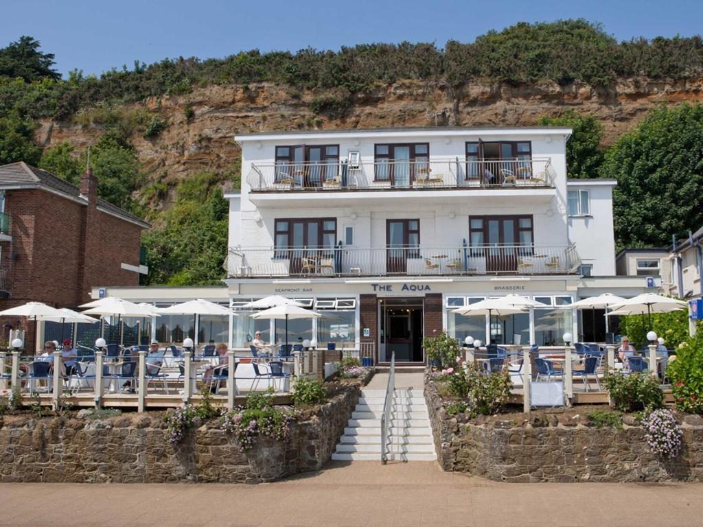 a building with tables and umbrellas in front of it at The Aqua in Shanklin