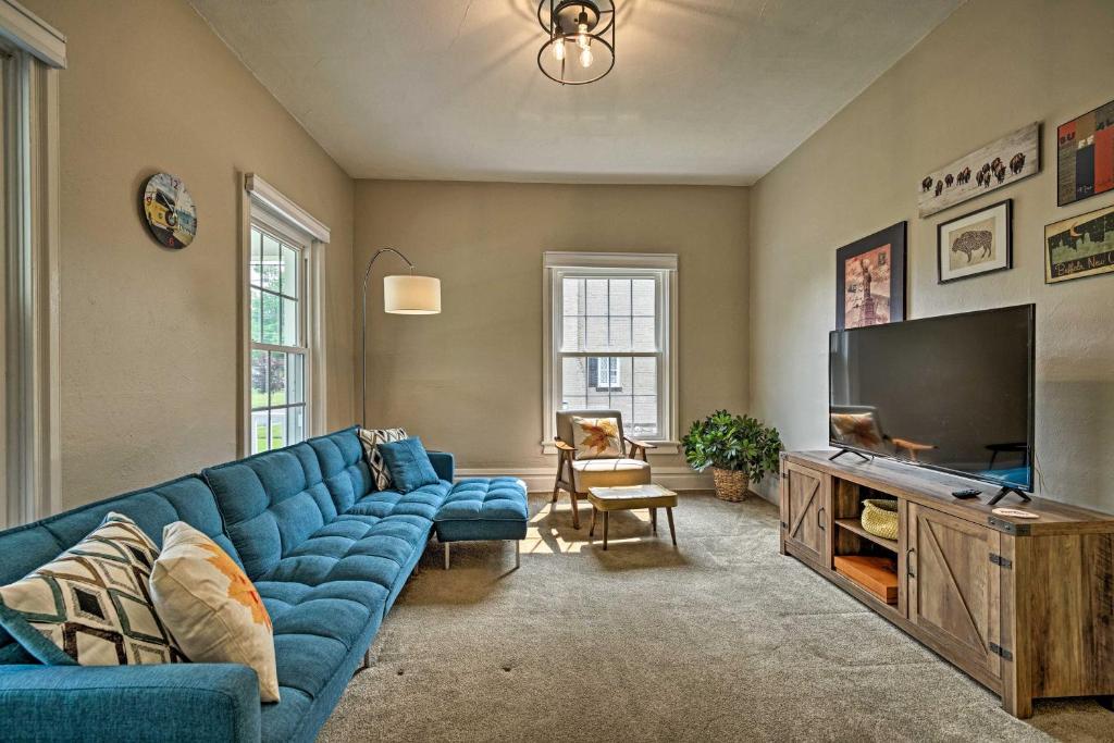 sala de estar con sofá azul y TV de pantalla plana en Charming and Historic Buffalo Home with Private Deck!, en Lancaster