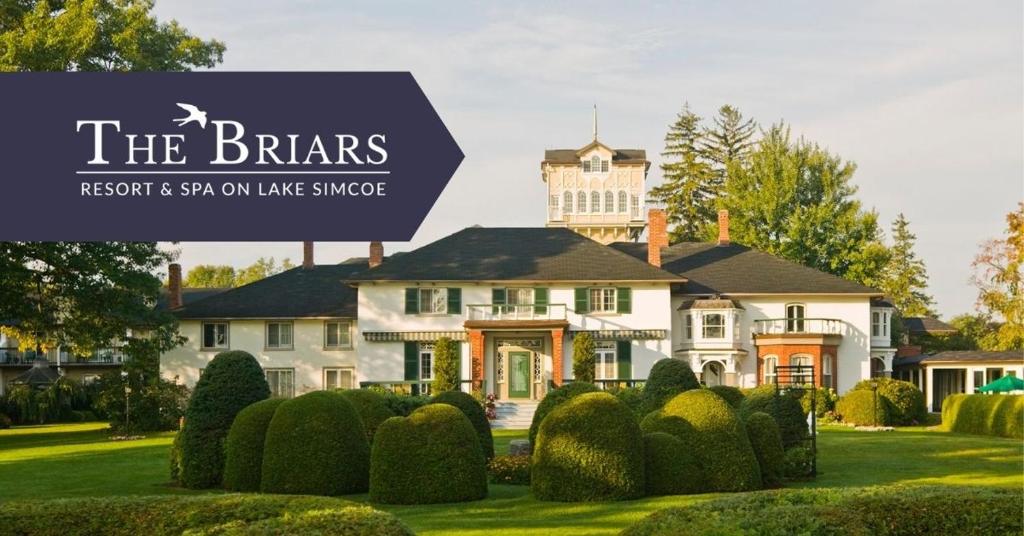 een huis met een bord dat leest het Brars resort en spa op het meer bij Briars Resort and Spa in Georgina