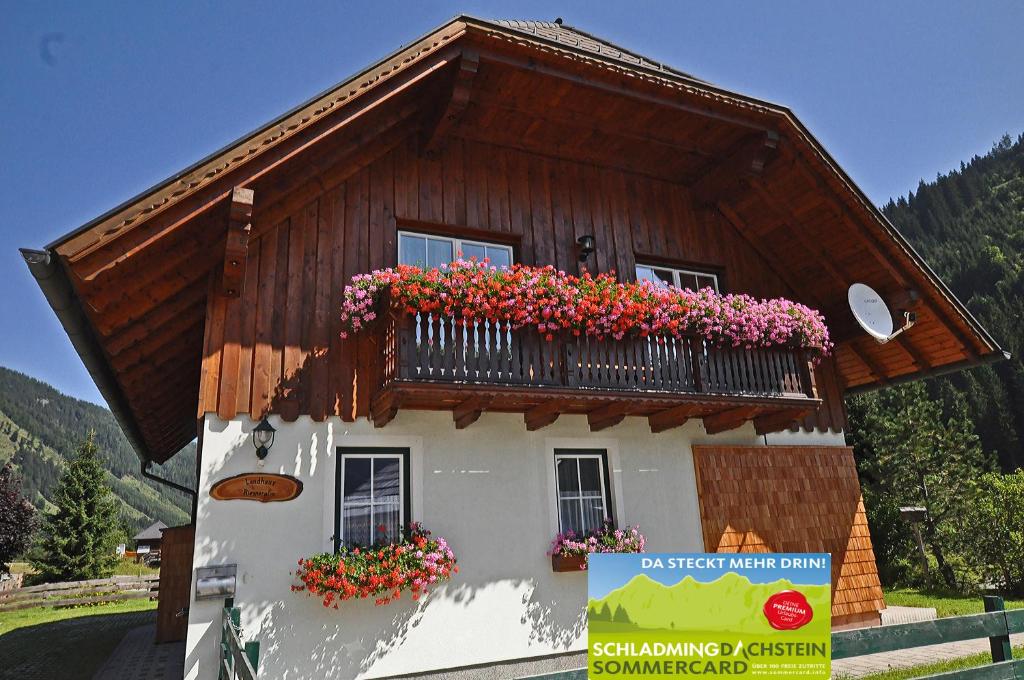 a house with a balcony with flowers on it at Landhaus Riesneralm in Donnersbachwald