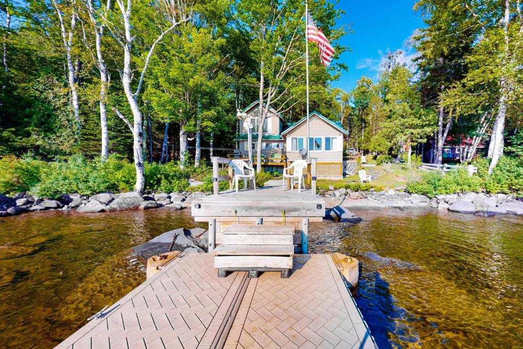 a dock in the middle of a river with a house at Lakeside Legacy in The Highlands