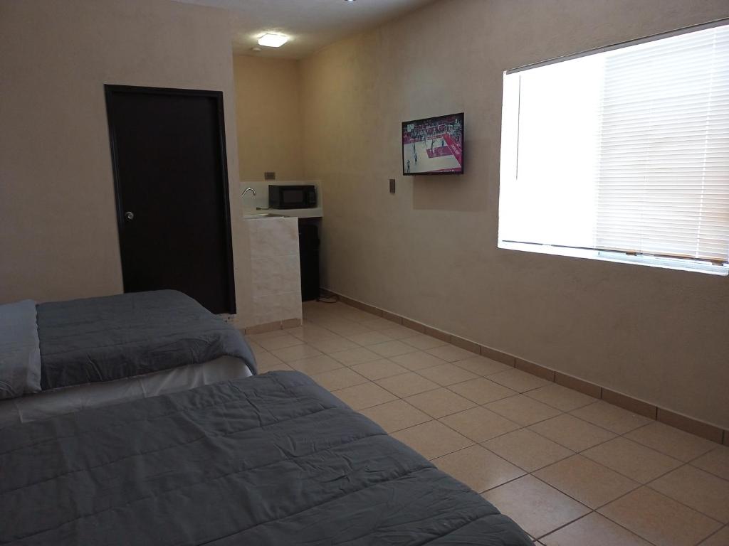 馬塔莫羅斯的住宿－LOSSANTOS，一间卧室设有两张床和大窗户
