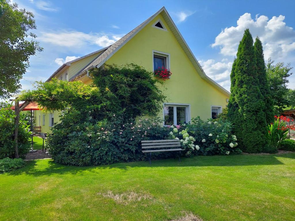 una casa amarilla con un banco en un patio en Ferienwohnung Lotte, en Felgentreu