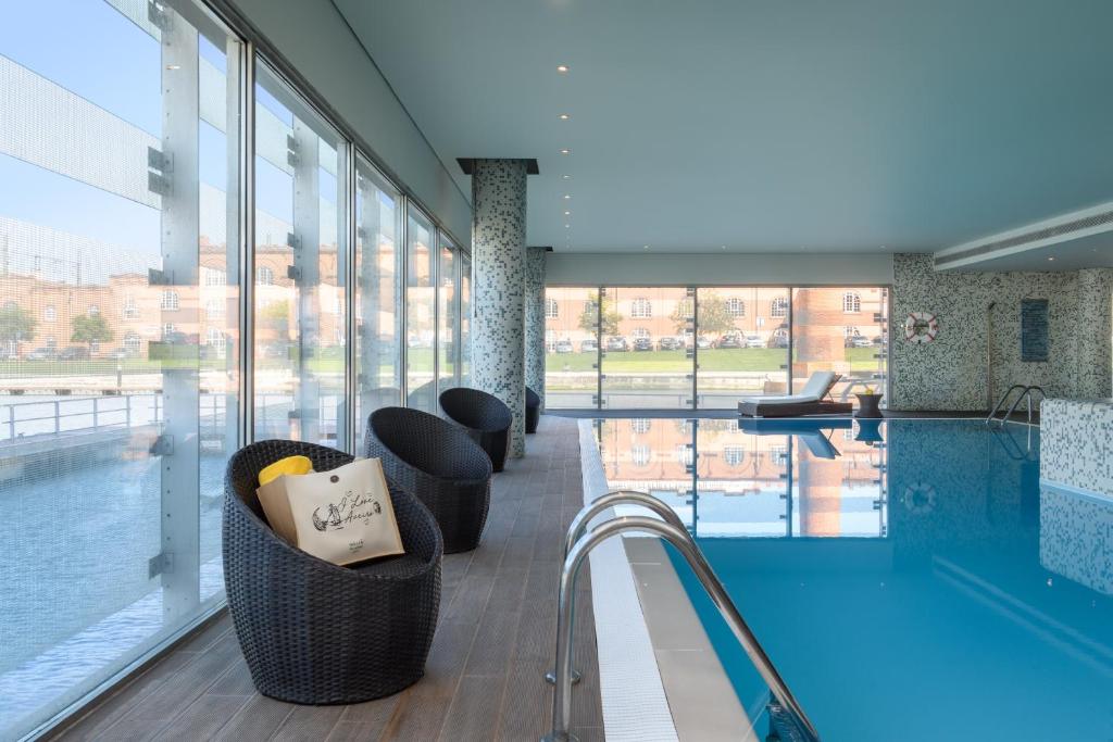 a large swimming pool with a large window at Melia Ria Hotel & Spa in Aveiro