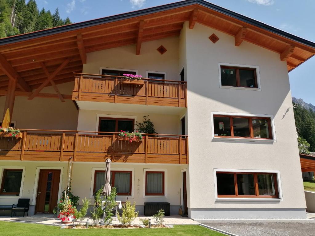 a large house with a balcony and a patio at Ferienwohnung Kaufbeurerhausblick in Hinterhornbach