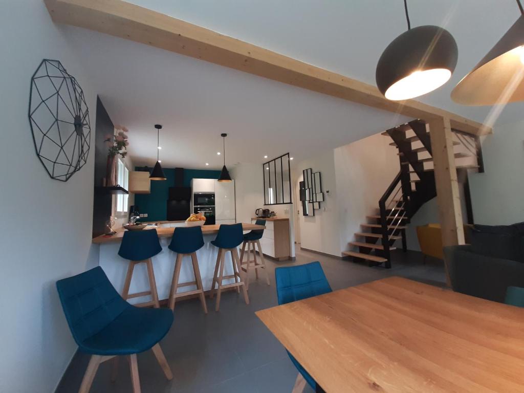 塞夫里耶的住宿－Villa du Lac - Clos Berthet，厨房以及带蓝色椅子和桌子的用餐室
