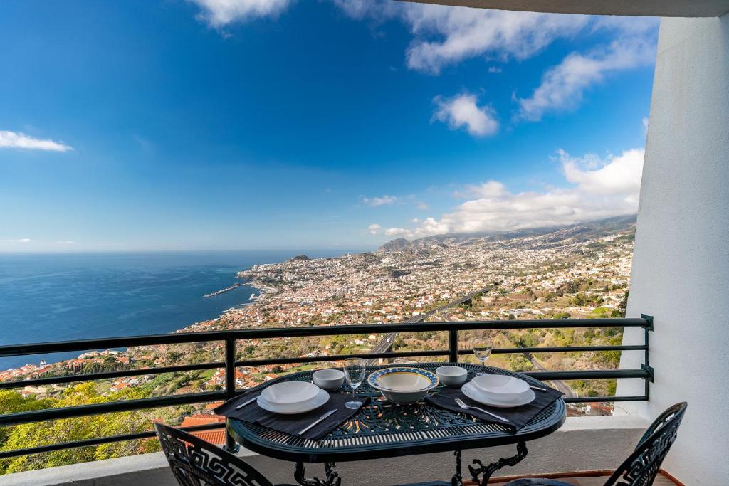 a table on a balcony with a view of the city at Atlantic Ocean view by HR Madeira in Funchal