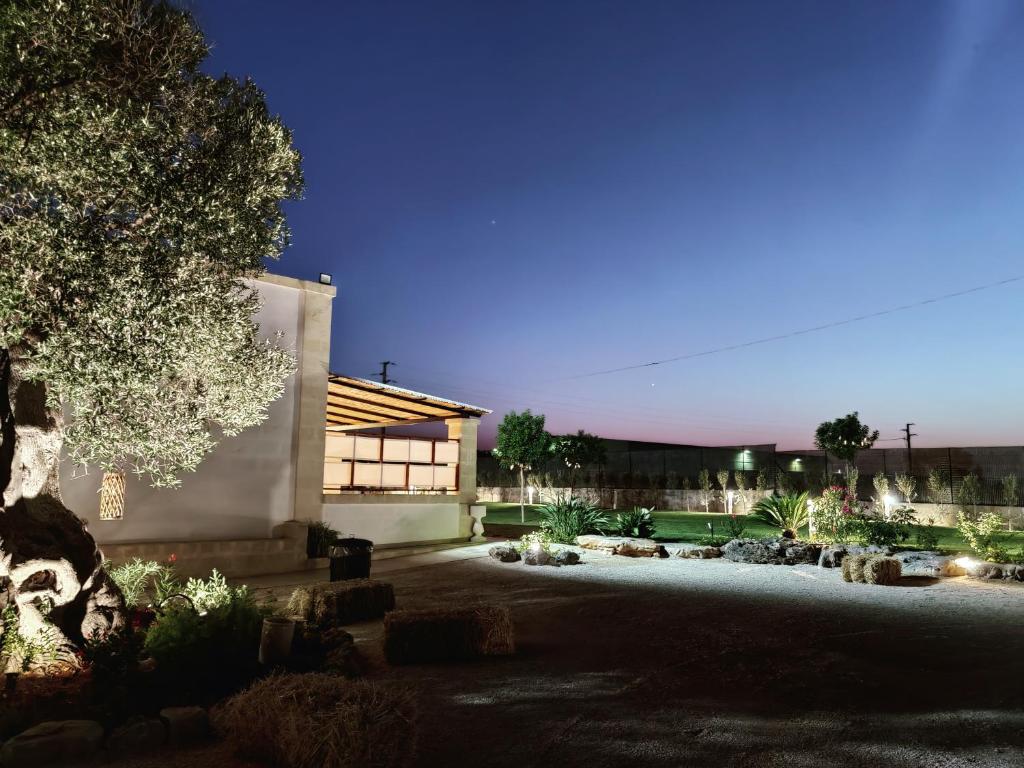 a garden at night with a building and a tree at Masseria Signora Cecca in Fasano