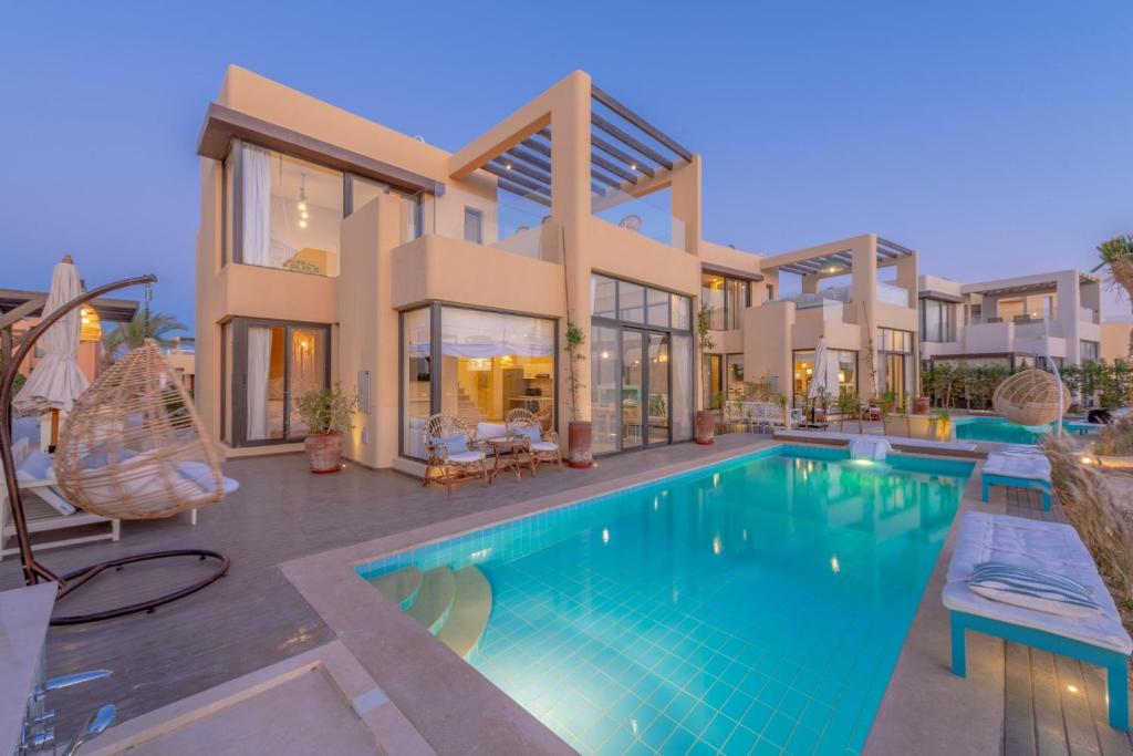 dom z basenem przed nim w obiekcie La Casa de Playa Tawila on Island 4BR Private with Heated Pool w mieście Hurghada