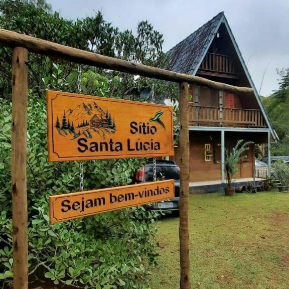 a sign in front of a house with a building at Sitio Santa Lucia in Santa Teresa