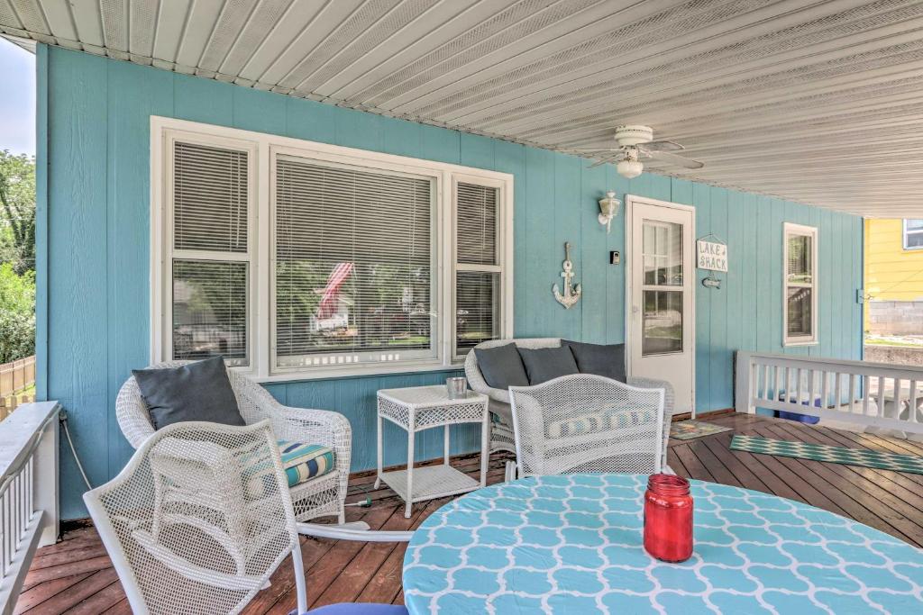 a room with chairs and a table on a porch at Cheerful Camdenton Cottage Steps to Lake! in Camdenton
