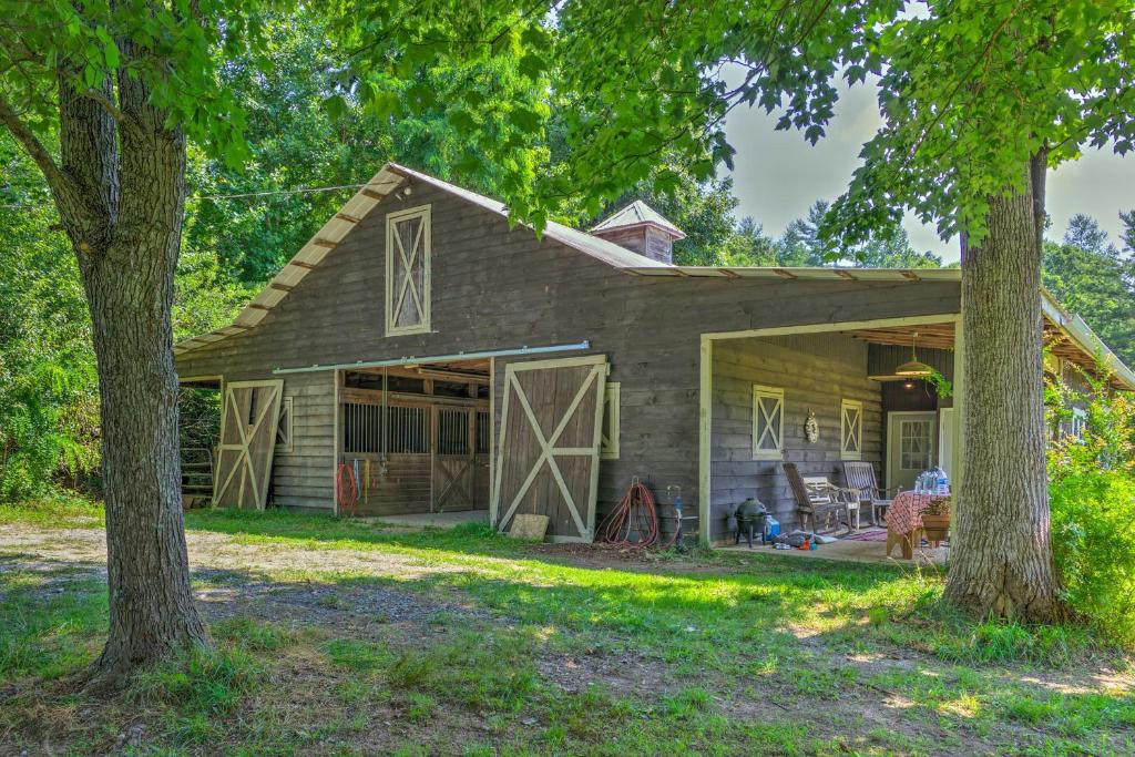 une maison avec un garage et deux arbres dans l'établissement Rustic and Authentic Farm Stay by DuPont Forest!, à Hendersonville
