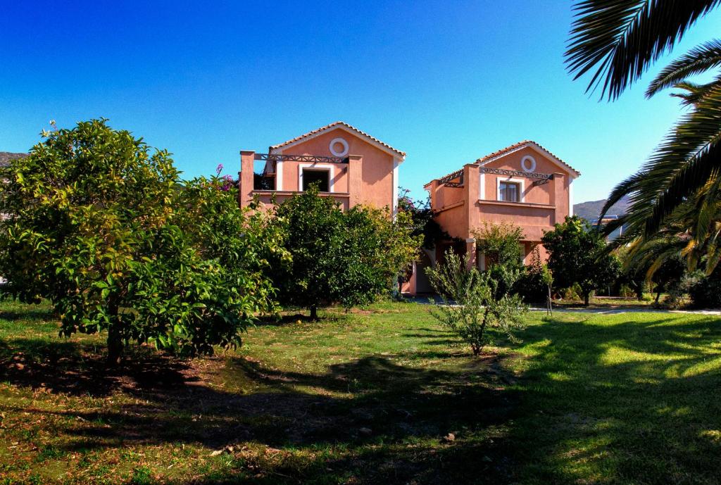 a house in a field with trees in front of it at Efrosini Village in Katelios