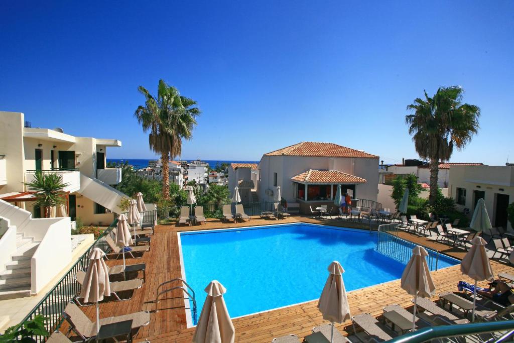 Blick auf den Pool in einem Resort mit Sonnenschirmen in der Unterkunft Eurohotel Katrin Suites in Stalida
