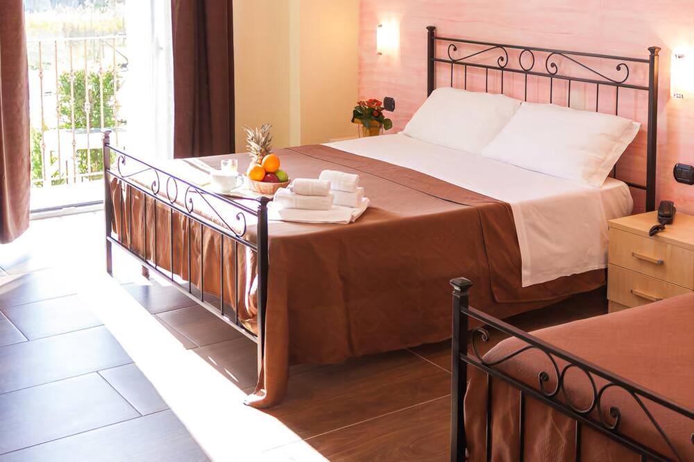 a bedroom with a large bed and a balcony at Mimí Hotel in Licata