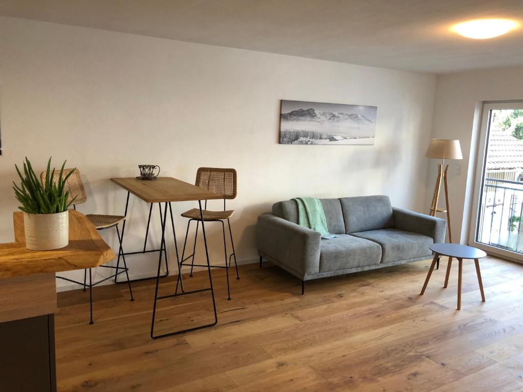 ein Wohnzimmer mit einem Sofa und einem Tisch in der Unterkunft Modernes Apartment in Gondelsheim