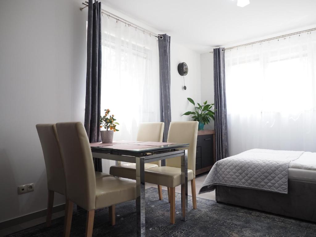 comedor con mesa, sillas y cama en Adobe Apartment, en Wroclaw