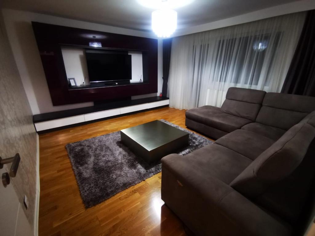 a living room with a couch and a flat screen tv at Luxury apartment. 10 minutes taxi ride to center in Timişoara