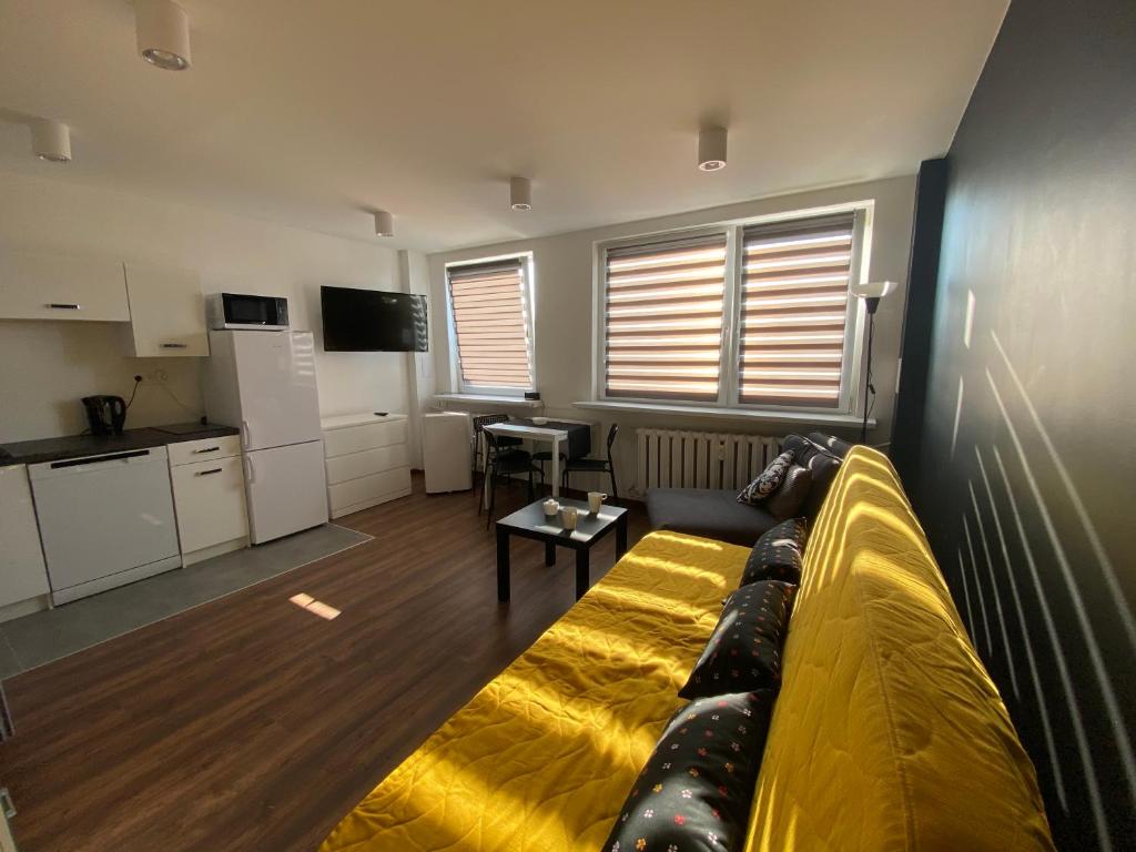 salon z kanapą i kuchnią w obiekcie Apartamenty Czapla w mieście Mikołajki