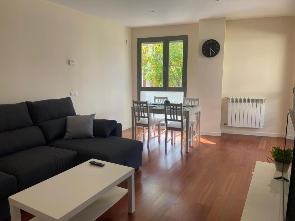 a living room with a couch and a table at Apartamento Pirineos, Urb Las Margas Golf in Sabiñánigo