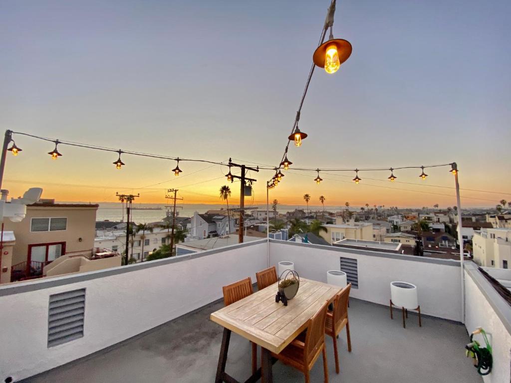 a wooden table on a balcony with a view of the city at Superb Long Beach House Steps to Sand w/ Roof Deck in Long Beach