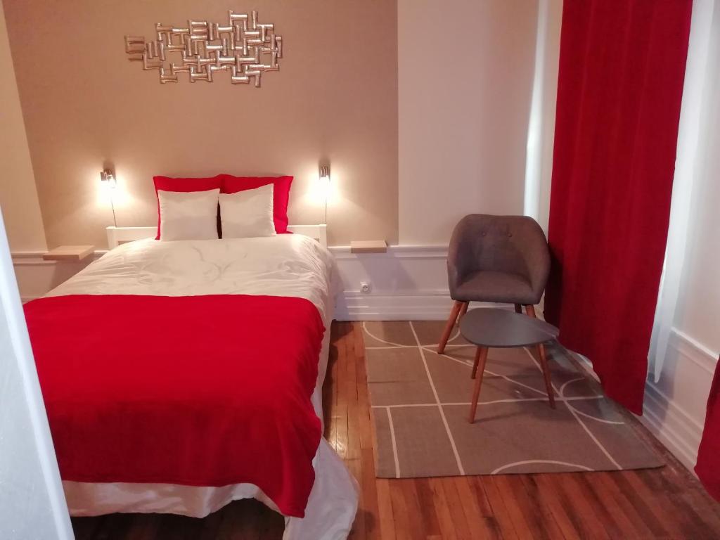 - une chambre avec un lit rouge et une chaise dans l'établissement Confort et Élégance dans le Bouchon de Champagne, à Troyes