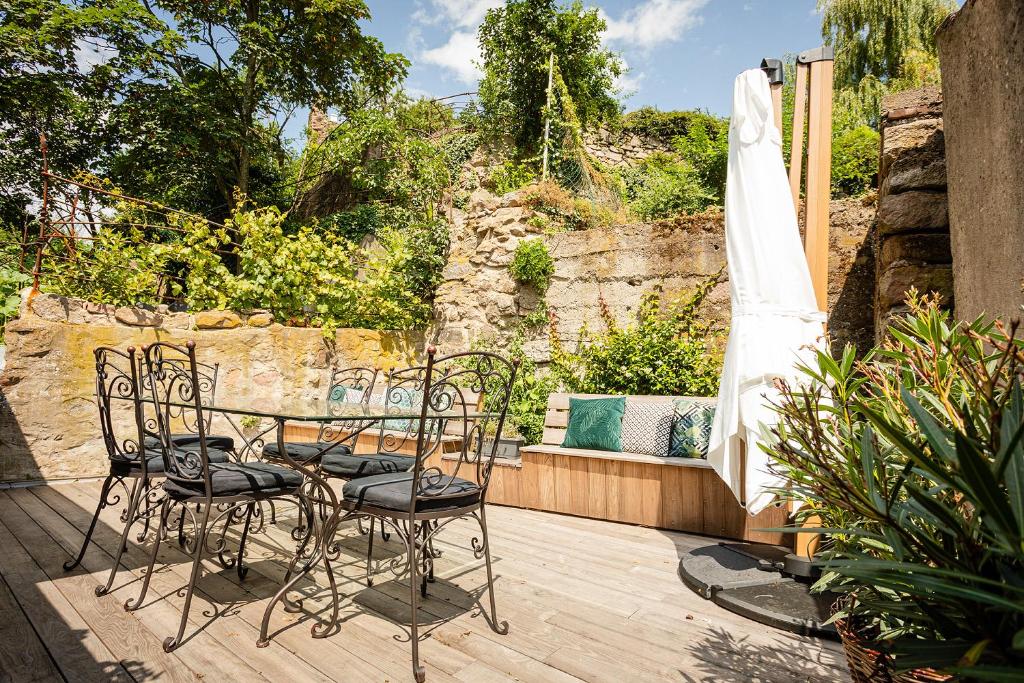 een tafel en stoelen op een houten terras bij Le Grenier du Photographe in Kaysersberg