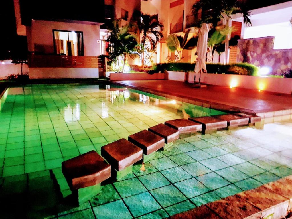 una piscina con bancos en medio de un edificio en Luxury 3 bedrooms Apartment Flic en Flac, en Flic en Flac