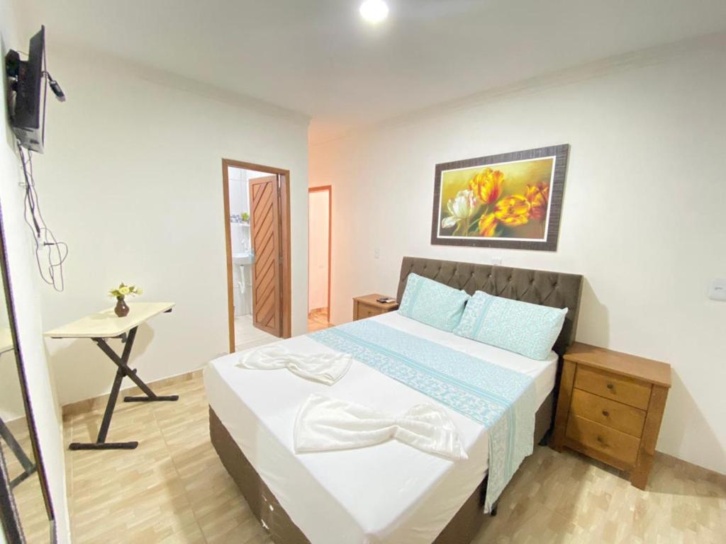 a bedroom with a bed and a table in it at Pousada O Mineiro - frente a praia in Galinhos