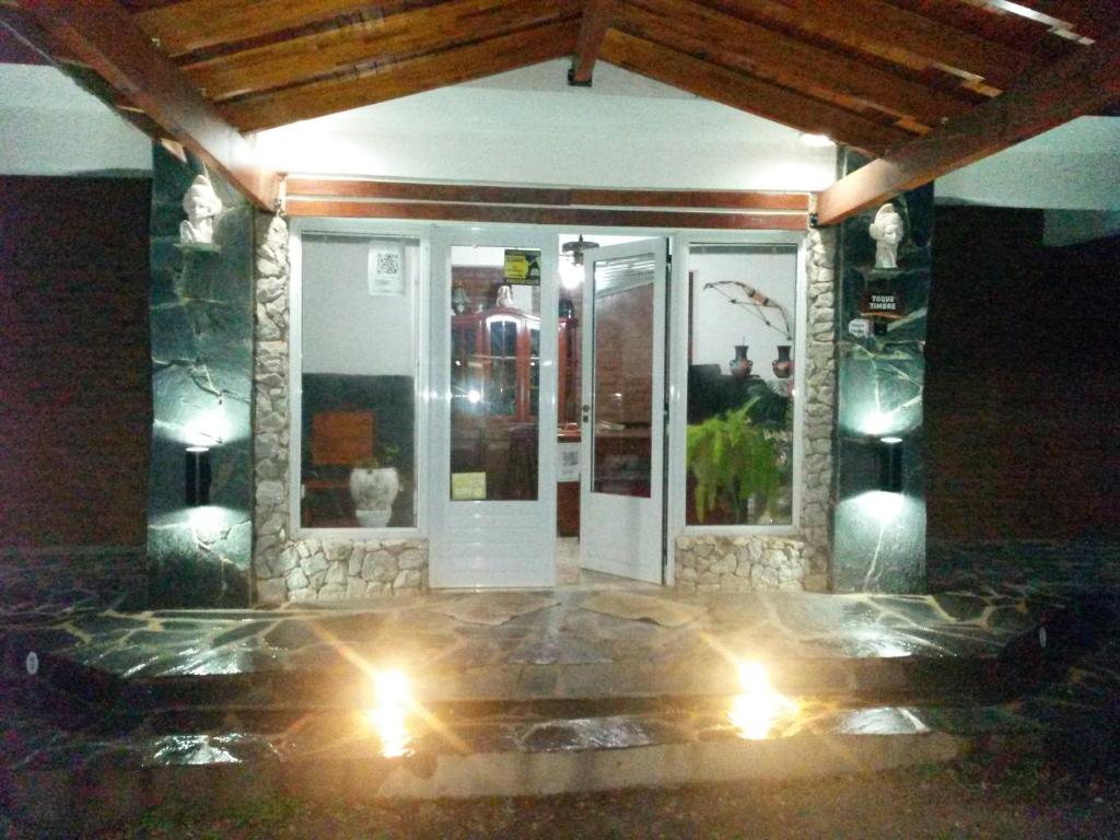 una puerta delantera de una casa por la noche con luces en Hotel Foxes en Villa del Dique