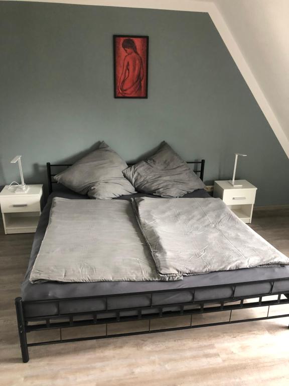 uma cama num quarto com duas mesas de cabeceira em Ferienwohnung an der A7 em Northeim