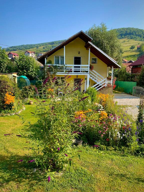 a house with a bunch of flowers in the yard at Family Flower House in Sarajevo