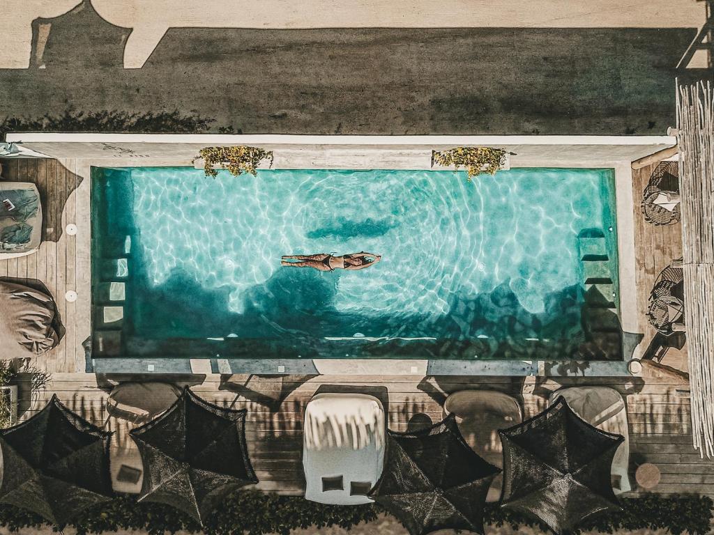 una pintura de una piscina con un barco en ella en Boutique Hotel EL NIDO Holbox, en Isla Holbox