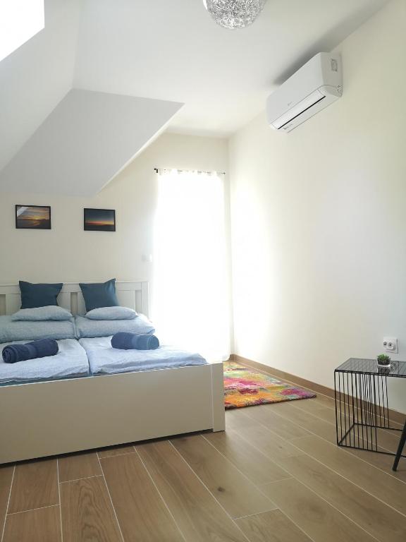 biała sypialnia z łóżkiem i oknem w obiekcie Forest House Balaton w mieście Cserszegtomaj