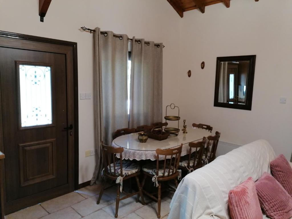 a dining room with a table and chairs and a window at House de Fountas in Khandria