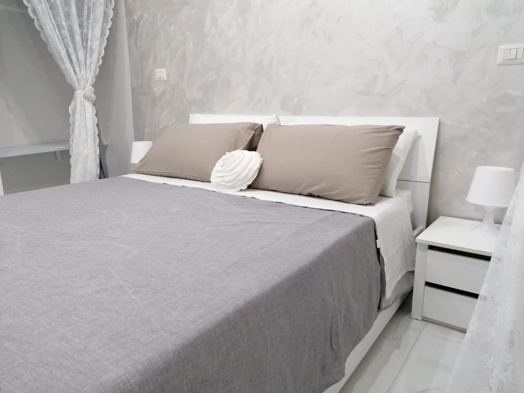 um quarto branco com uma cama com 2 almofadas em [Centro Storico] Casa Elegante per Famiglia em Nápoles