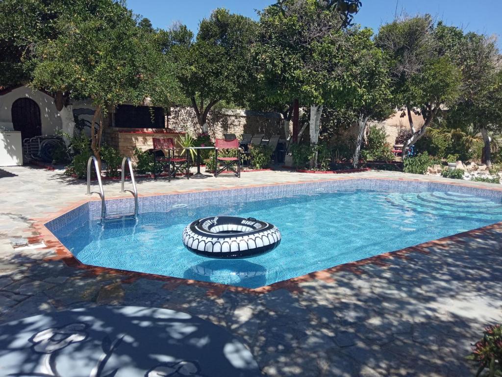 a swimming pool with a tire in the middle of it at Εlegant Villa Liakos in Pigi