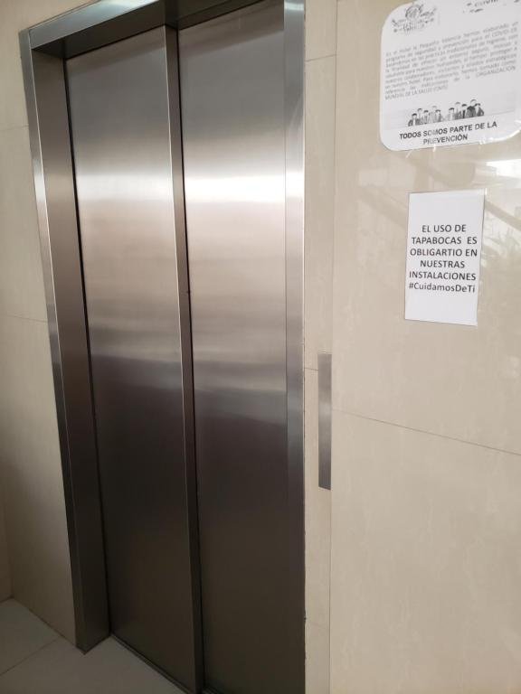 Un gran ascensor metálico con un cartel. en Hotel La Pequena Valencia, en Valencia