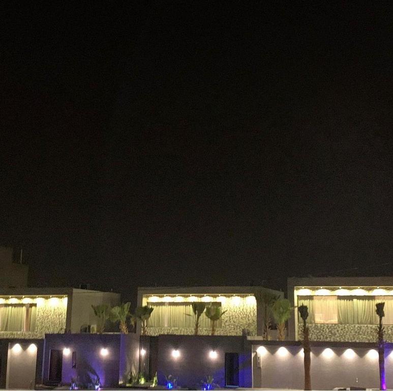 un edificio iluminado por la noche con luces en View Villas en Buraidah