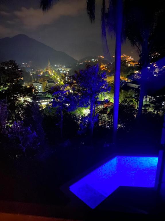 a night view of a swimming pool with a city at BELA VISTA RESERVAs in Petrópolis