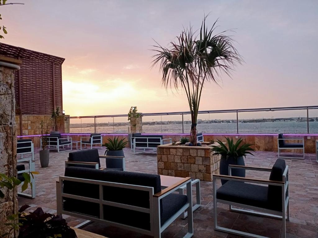 a patio with chairs and a palm tree at RAK Hotel Apartments in Jeddah
